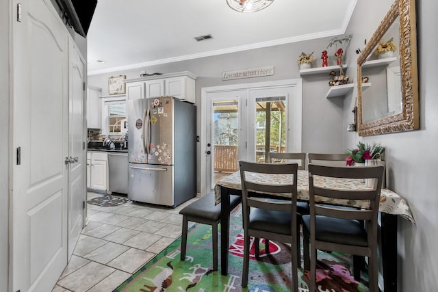 dining area featuring ornamental molding and light tile patterned flooring