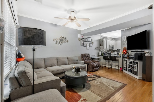 living room featuring crown molding, ceiling fan, and light hardwood / wood-style floors