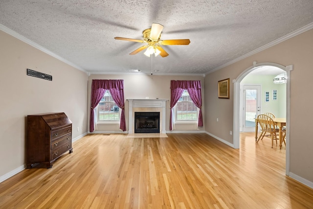 unfurnished living room with crown molding, a healthy amount of sunlight, and light hardwood / wood-style flooring