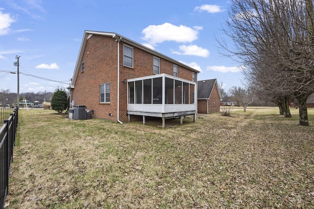 rear view of property with a sunroom, a yard, and cooling unit