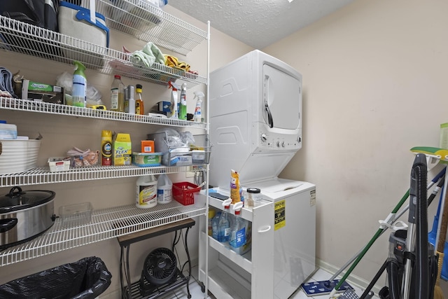 laundry area with stacked washing maching and dryer and a textured ceiling