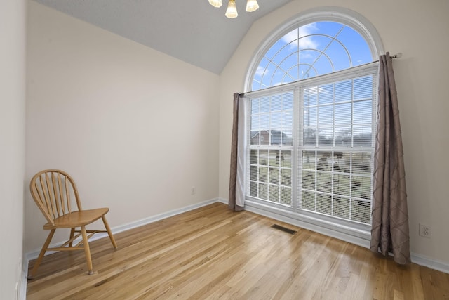 spare room with vaulted ceiling and light hardwood / wood-style floors