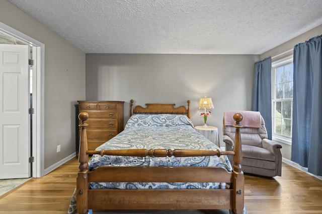 bedroom featuring wood-type flooring and a textured ceiling