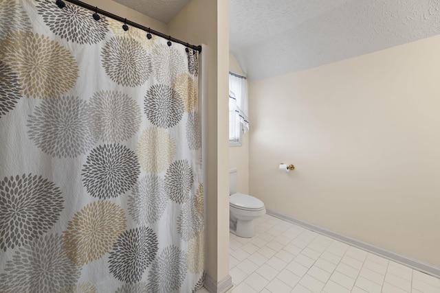 bathroom featuring lofted ceiling, tile patterned floors, toilet, and a textured ceiling