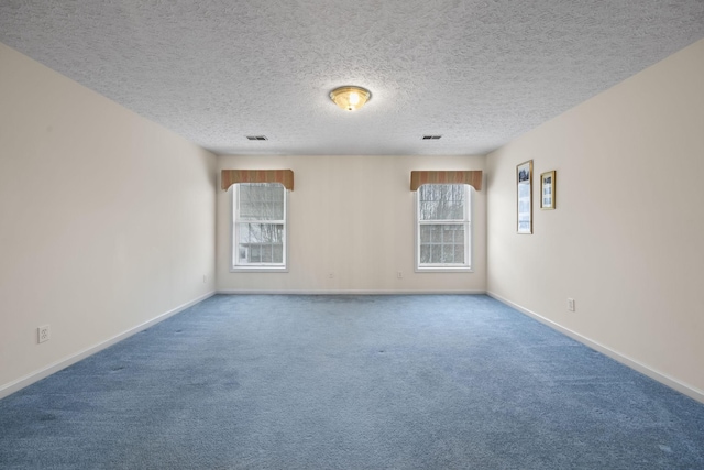 carpeted empty room with a textured ceiling