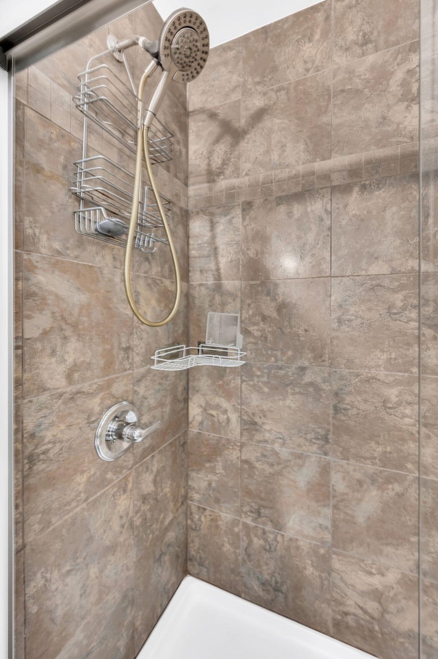 interior details featuring a tile shower