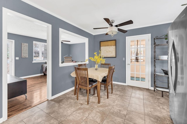 tiled dining area with ceiling fan and ornamental molding