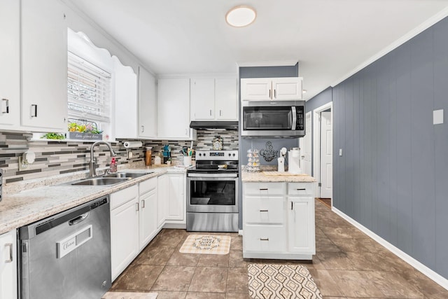 kitchen featuring appliances with stainless steel finishes, sink, white cabinets, decorative backsplash, and light stone countertops