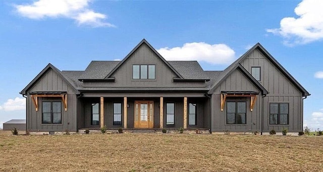 modern inspired farmhouse with a front lawn and a porch