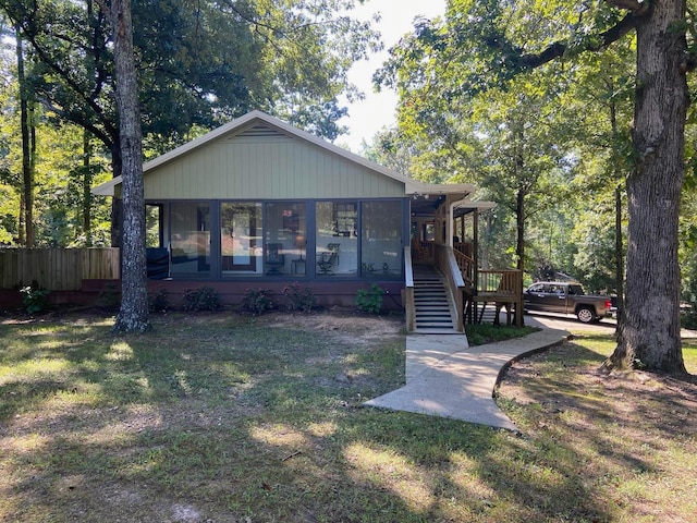 view of front of home featuring a front lawn and a sunroom