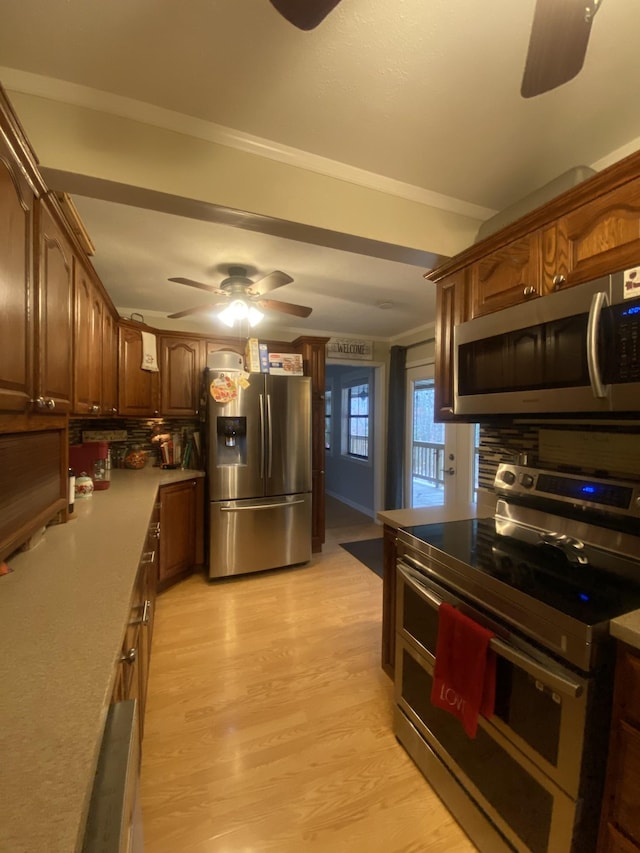 kitchen with stainless steel appliances, ceiling fan, backsplash, and light wood-type flooring