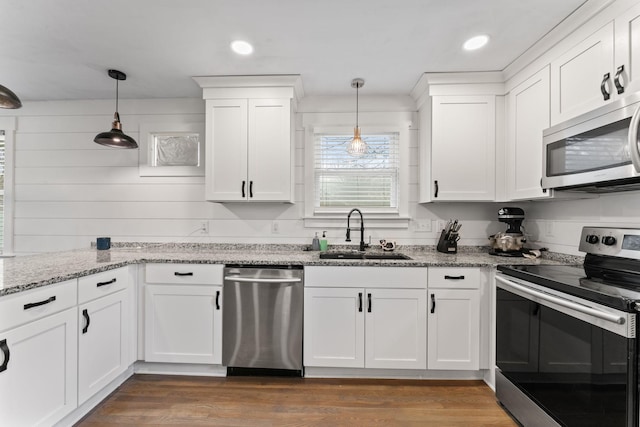 kitchen with white cabinetry, sink, stainless steel appliances, and hanging light fixtures