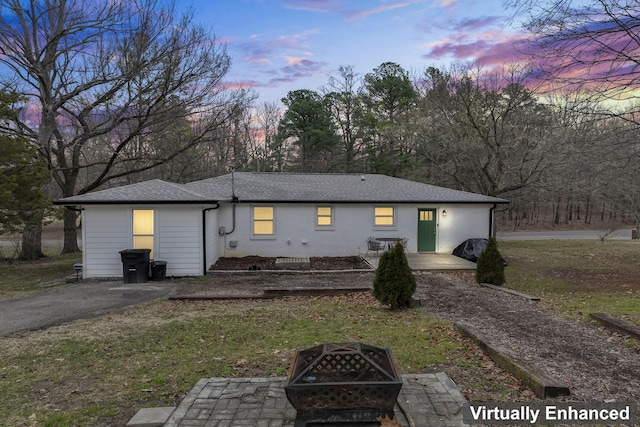 view of front of property with a yard and an outdoor fire pit