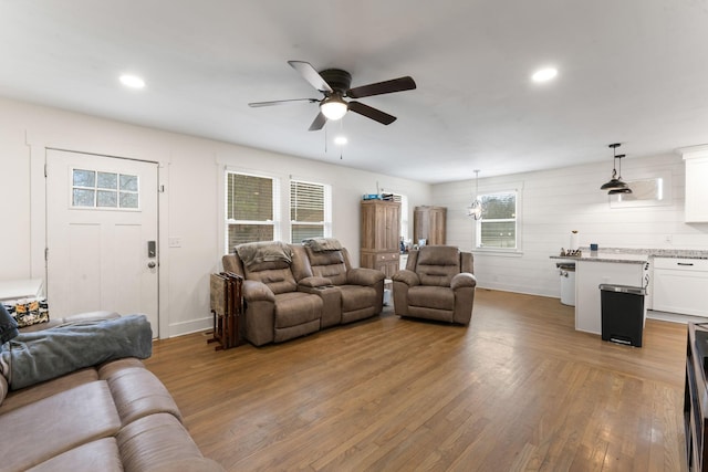 living room with light hardwood / wood-style floors and ceiling fan