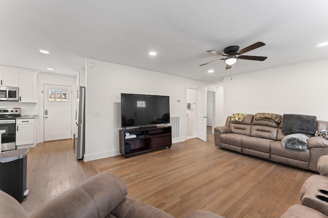 living room featuring ceiling fan and light wood-type flooring