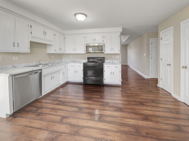 kitchen with sink, dark wood-type flooring, stainless steel appliances, and white cabinets