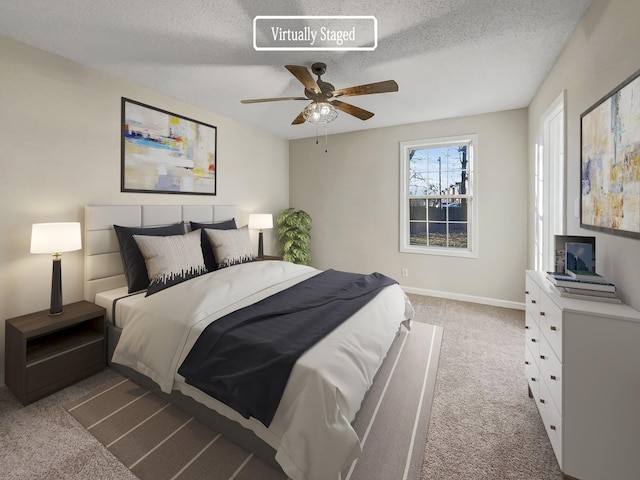 carpeted bedroom with ceiling fan and a textured ceiling