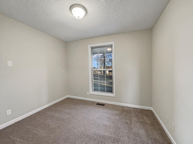 spare room featuring carpet and a textured ceiling