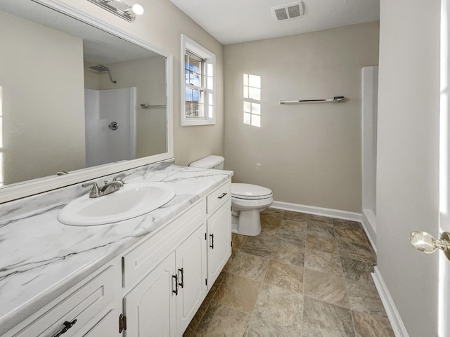 bathroom with vanity, toilet, and a shower