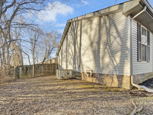 view of side of property featuring crawl space and fence