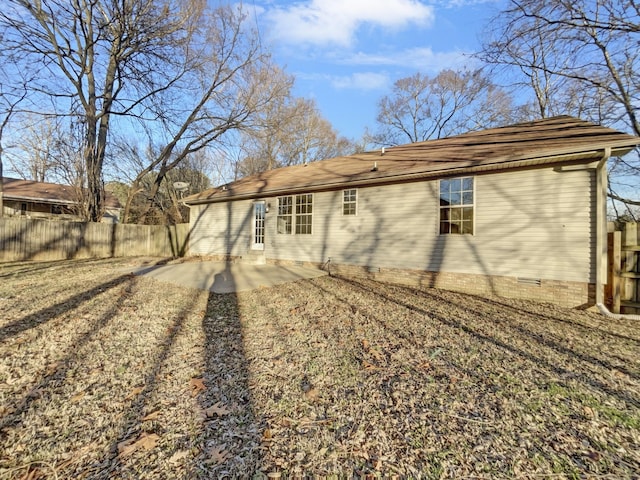 rear view of property with crawl space, a patio area, and fence