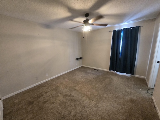 empty room with carpet floors, a textured ceiling, baseboards, and a ceiling fan