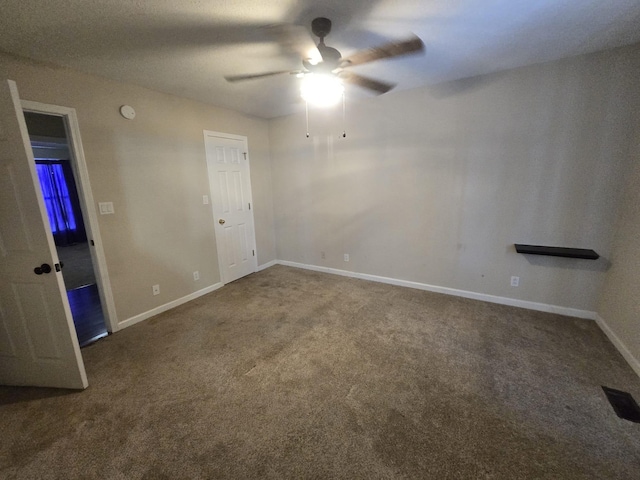 carpeted spare room with a ceiling fan, visible vents, and baseboards