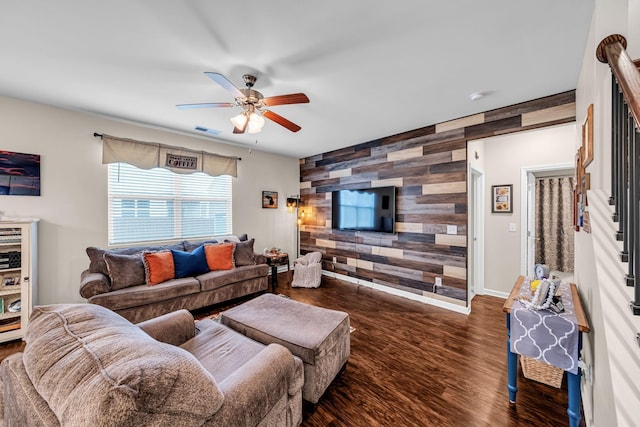 living room with ceiling fan, dark hardwood / wood-style flooring, and wood walls