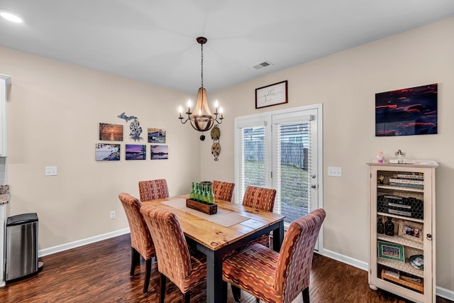 dining space featuring dark hardwood / wood-style flooring and a notable chandelier