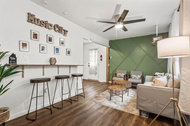 living room with ceiling fan and dark hardwood / wood-style flooring