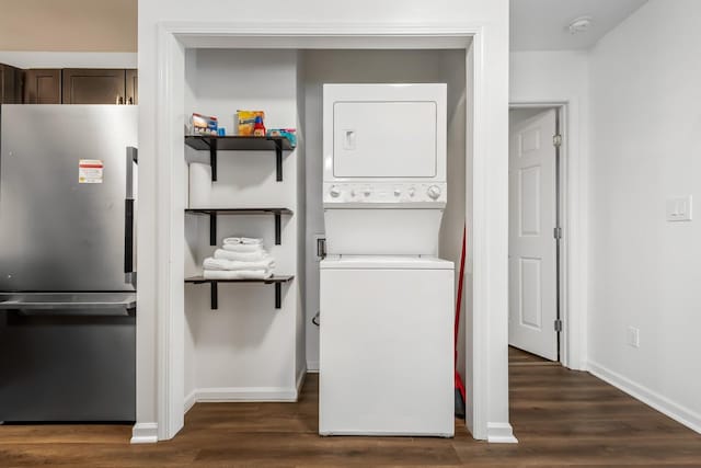 laundry area featuring dark hardwood / wood-style flooring and stacked washer / drying machine