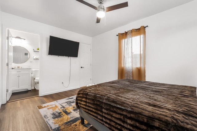 bedroom featuring ceiling fan, ensuite bathroom, and dark hardwood / wood-style floors