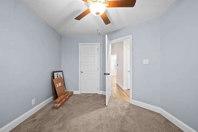 interior space with light carpet and ceiling fan