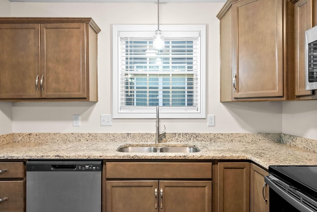 kitchen featuring pendant lighting, sink, stainless steel dishwasher, and light stone counters