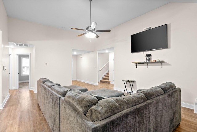 living room with ceiling fan, vaulted ceiling, and wood-type flooring