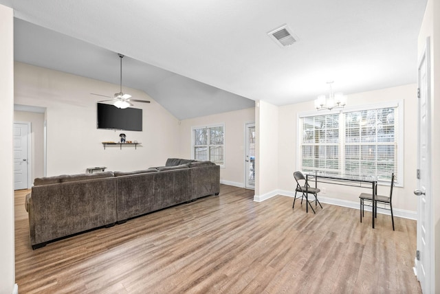 living room featuring lofted ceiling, a wealth of natural light, and light wood-type flooring