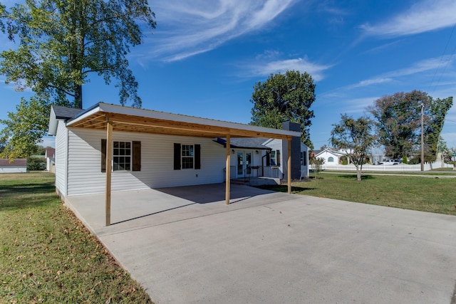 rear view of property with a yard and a carport