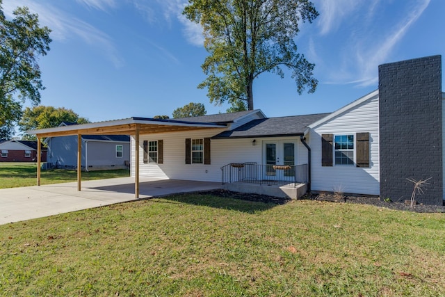 rear view of house with a carport and a yard