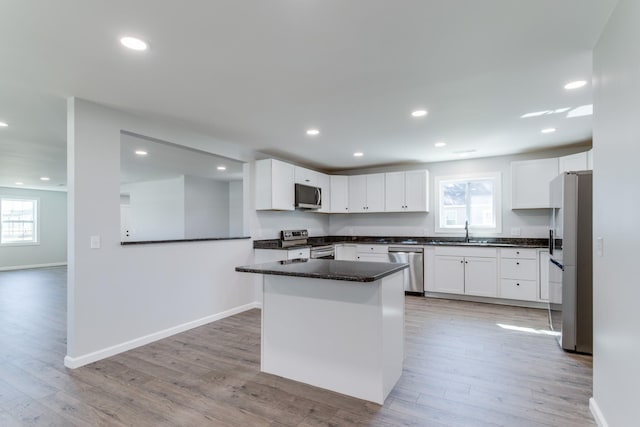 kitchen featuring a healthy amount of sunlight, appliances with stainless steel finishes, sink, and white cabinets