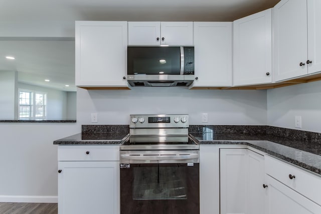 kitchen featuring dark stone counters, white cabinets, and appliances with stainless steel finishes