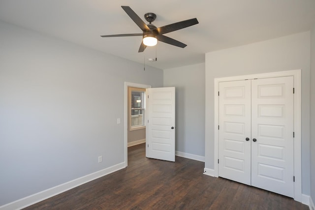 unfurnished bedroom featuring ceiling fan, dark hardwood / wood-style flooring, and a closet