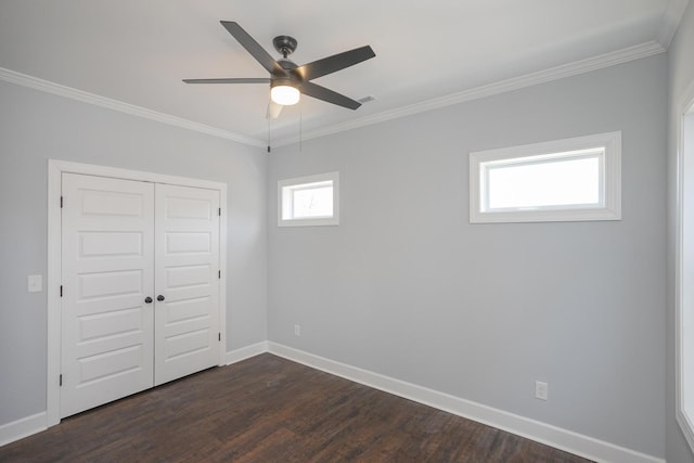 unfurnished bedroom with crown molding, dark wood-type flooring, ceiling fan, and a closet