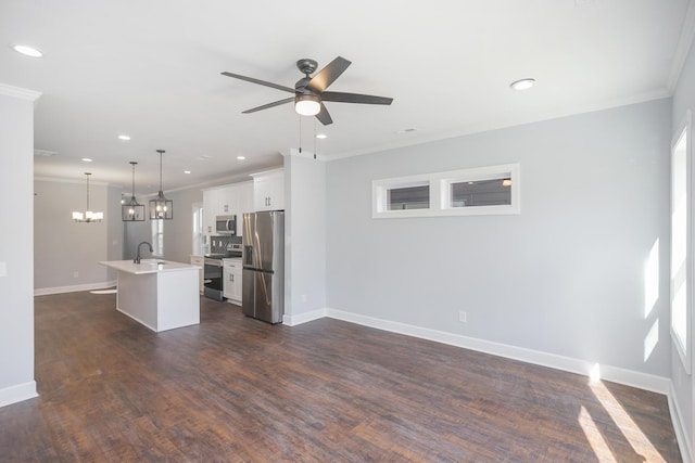 kitchen with pendant lighting, a kitchen island with sink, white cabinetry, stainless steel appliances, and ornamental molding