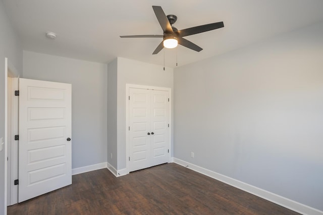 unfurnished bedroom featuring dark hardwood / wood-style floors, ceiling fan, and a closet