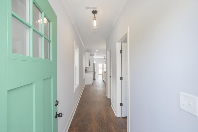 hallway with ornamental molding and dark hardwood / wood-style floors