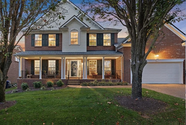 view of front of home featuring a porch, a garage, and a lawn