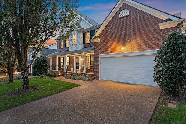 view of front of house with a porch, a garage, and a lawn