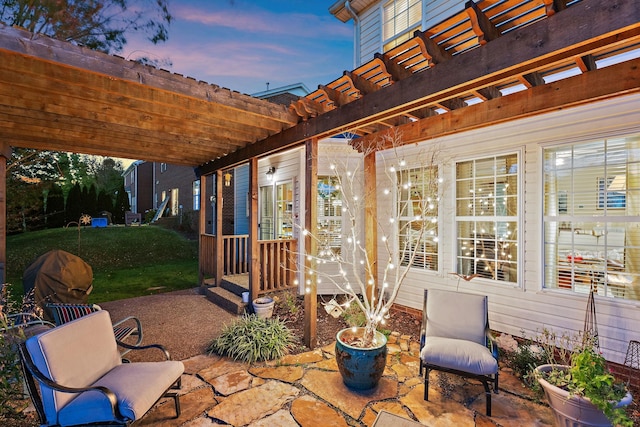 patio terrace at dusk with a pergola and a lawn