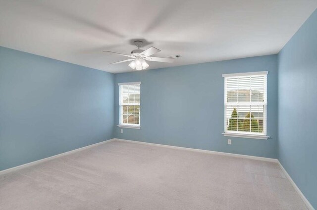 empty room featuring light colored carpet and ceiling fan