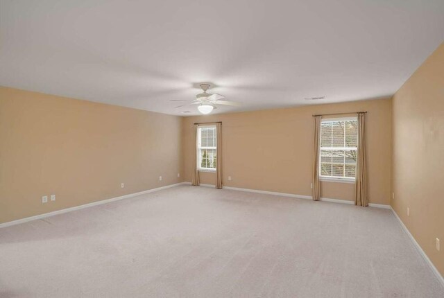 empty room featuring light colored carpet and ceiling fan